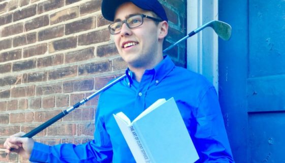 A photo of Bryce, an intern at The Blu Group, holding a book and golf club.