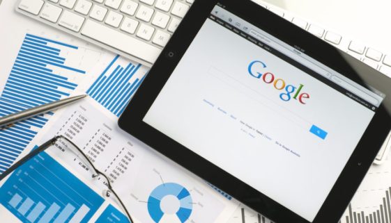tablet-displaying-google-search-screen-on-loose-papers-with-business-analytics