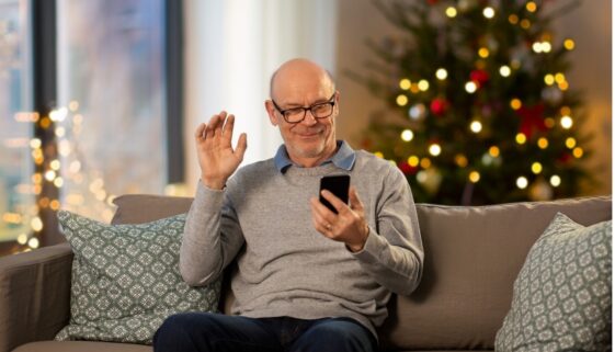 the-blu-group-advertising-&-marketing-accessibility-importance-during-holidays-man-on-couch-with-phone-holiday