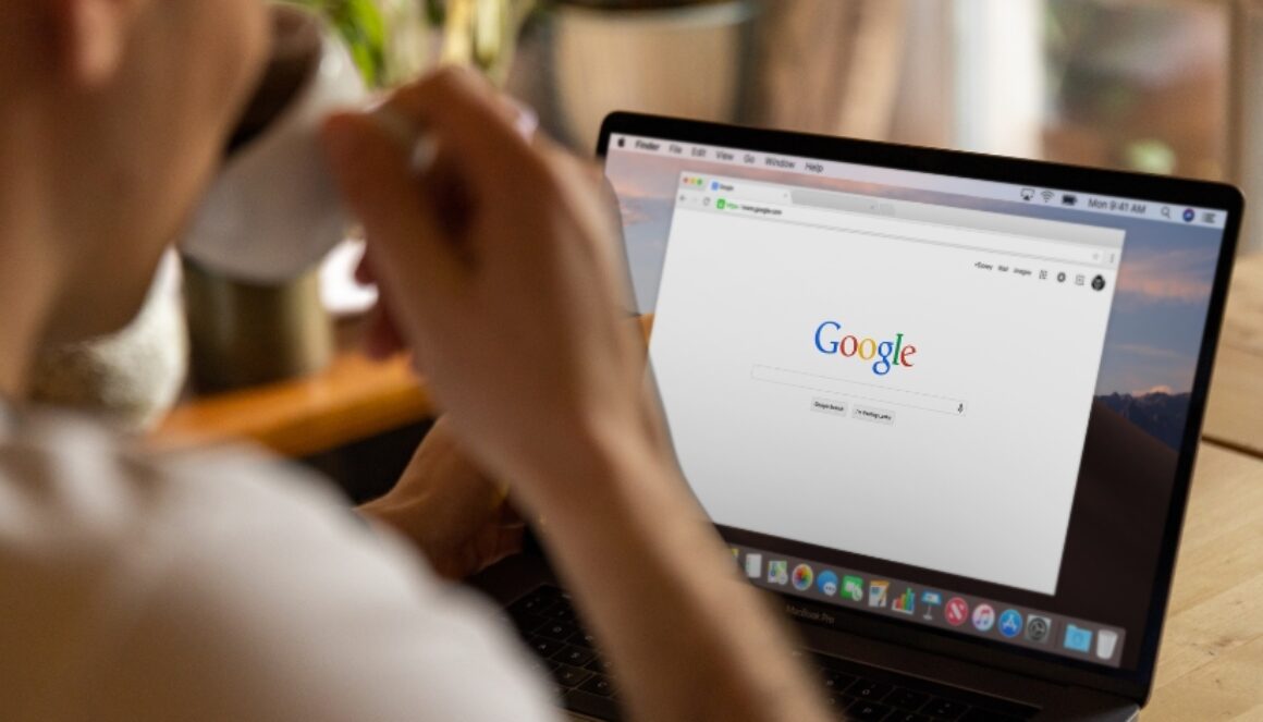 Person sitting at a table with a new Google search tab open on their laptop.