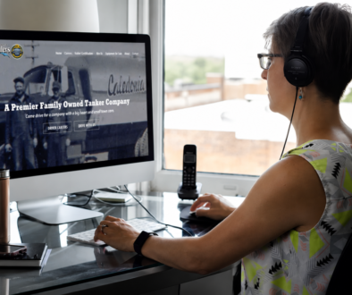 The BLU Group Advertising & Marketing head designer, Lucy, reviews the Caledonia Haulers website on a desktop computer.