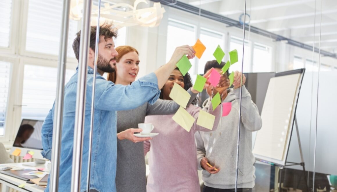 Team members collaborate on content planning and marketing strategy using sticky notes during a brainstorming session.